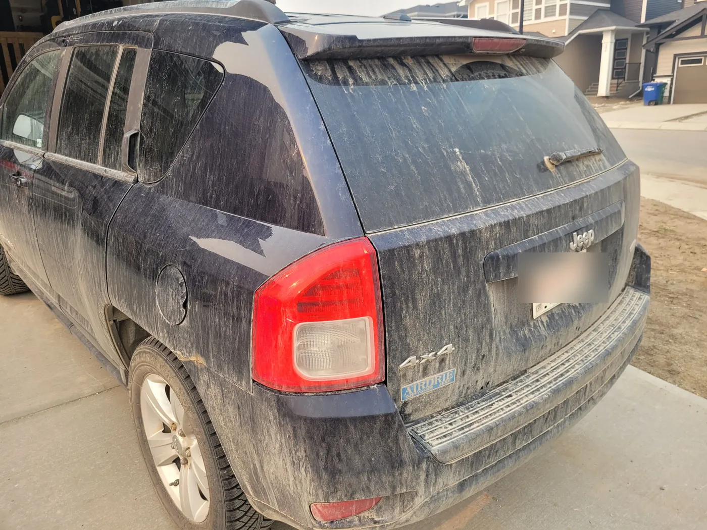 A Jeep Compass streaked with white road salt