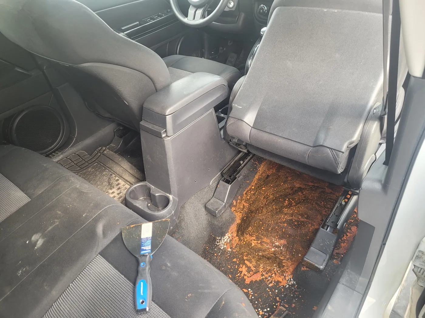 A rear footwell with a large dried spill ground into the carpet